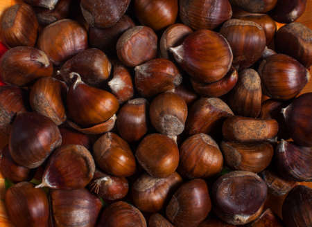 Group of chestnuts illuminated by a light side. Dark background. Autumn background.の写真素材