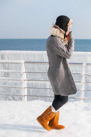 portrait of young attractive woman with scarf on winter beach.の写真素材