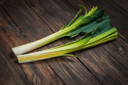 fresh organic leeks tied on an old wooden board.の写真素材