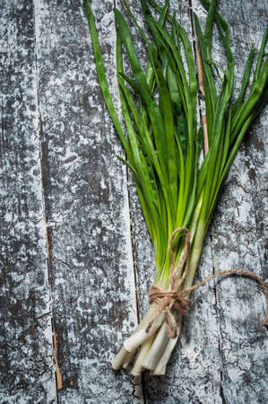 bunch of spring onion on a wood table.の写真素材