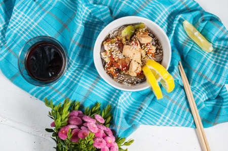 Cooked funchoza with chicken fillet and toasted sesame seeds.