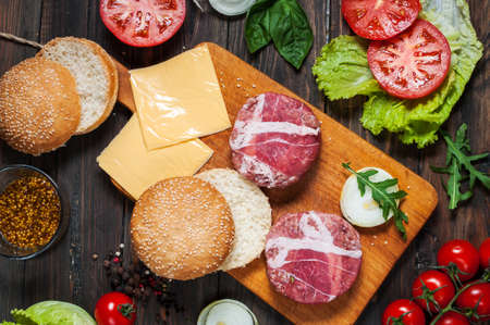 Ingredients for making homemade burger on wooden cutting board. Top view.の写真素材