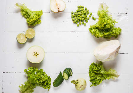 collection of green vegetables and fruits on white wooden background. Top view. Space for text.の写真素材