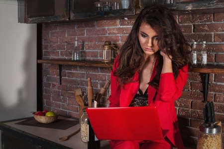 Smart business woman working on her laptop at home in kitchen.の写真素材