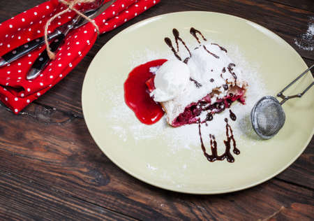 Christmas cherry strudel with ice cream on wood table.の写真素材