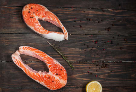 Fresh salmon slice with spice on old wood background.の写真素材