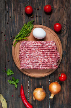 Homemade raw minced meat with egg and herbs closeup, top view.の写真素材