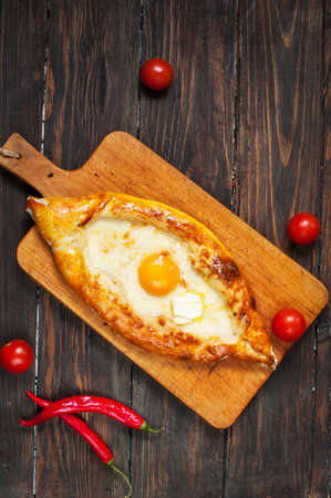 Hachapuri on Adjara. Beautiful open pies khachapuri with egg on wooden background. Top viewの写真素材