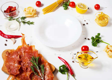 Background with pasta, tomatoes cherry and meat on white wooden table. Place for text. の写真素材
