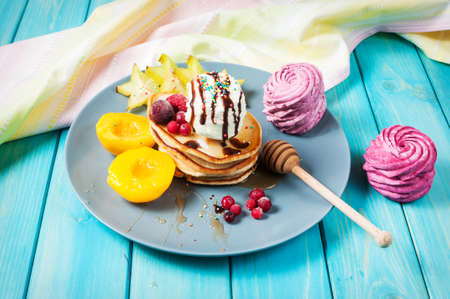 Pancakes with Vanilla Ice Cream on blue wood plate.の写真素材