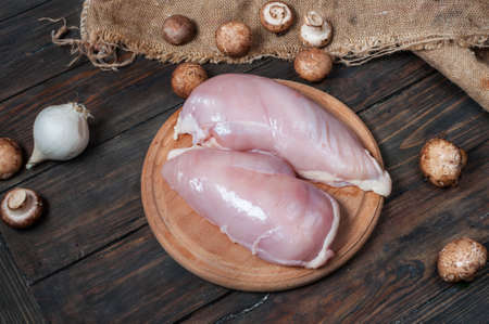 chicken fillet and mushrooms on a wooden tableの写真素材