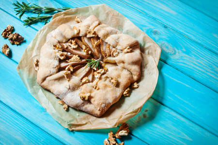homemade cake with pears and walnuts on blue wood background.の写真素材