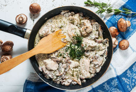 Chicken breast with mushrooms in cream sauce on a pan on the table. top view.の写真素材