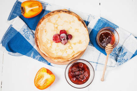 Pancakes on cutting board on white wooden background. Selective focus.の写真素材