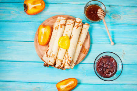 Pancakes on cutting board on blue wooden background. Selective focus.の写真素材