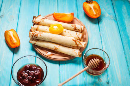 Pancakes on cutting board on blue wooden background. Selective focus.の写真素材