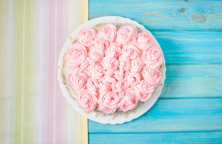 Cake with pink cream on blue wood background. Pink cake.