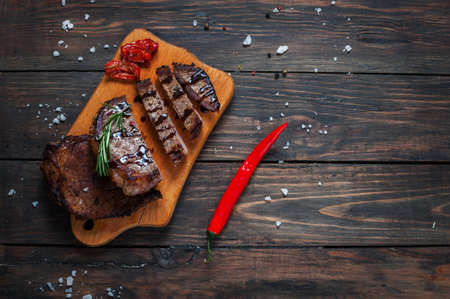 Grilled beef steak seasoned with spices served on a wooden boardの写真素材