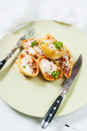 Conchigliei pasta stuffed with a ricotta cheese, mozzarella and meat on white wood table.の写真素材