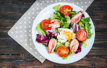 Healthy Shrimp and Arugula Salad with Tomatoes on a wooden table. Top viewの写真素材