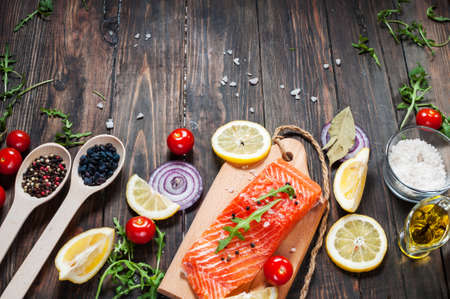 Delicious portion of fresh salmon fillet with aromatic herbs, spices and vegetables - healthy food,...
