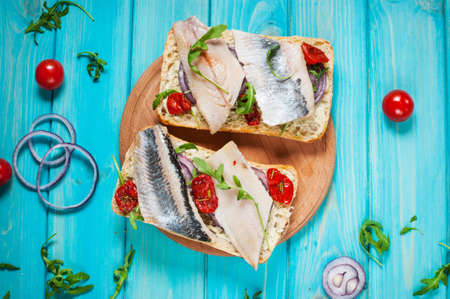 sandwich with herring and onion on blue wooden table. Top viewの写真素材