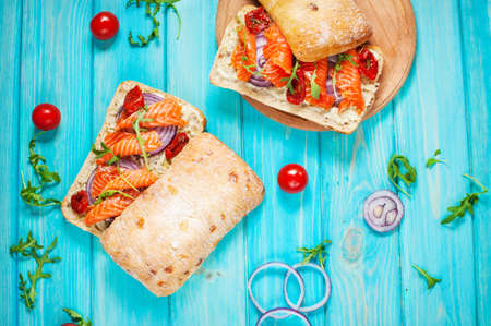 sandwich with smoked salmon on blue wooden table. Top viewの写真素材