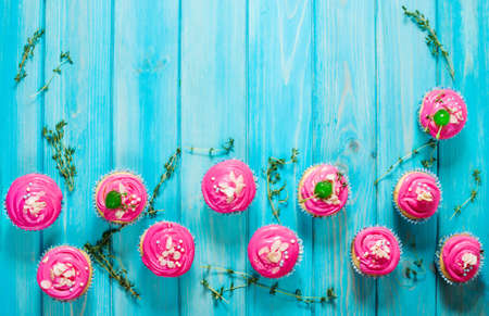 Colorful pink Cupcakes on blue wood background. Top view and copyspaceの写真素材