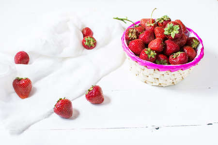 fresh strawberries in a basket on wood backgroundの写真素材