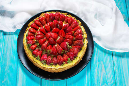 Cheesecake with strawberries, bio homemade strawberries from garden on wood backgroundの写真素材