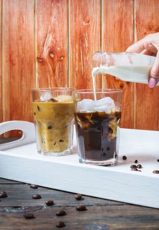 Iced coffee in glass on wood background.