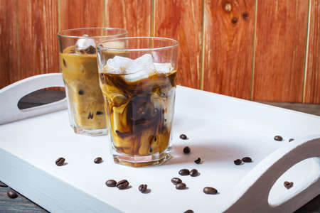 Iced coffee in glass on wood background.