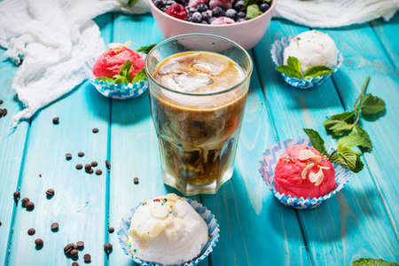 Iced coffee in glass and ice cream on blue wood backgroundの写真素材