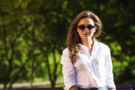 Woman resting at the park. girl in sunglasses, outdoor summer portrait.の写真素材