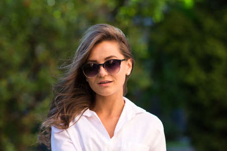 Woman resting at the park. girl in sunglasses, outdoor summer portrait.の写真素材