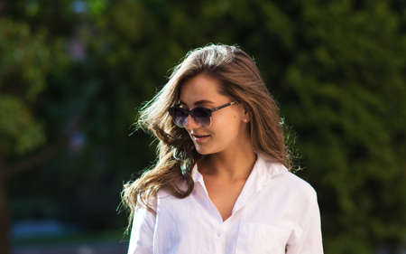 Woman resting at the park. girl in sunglasses, outdoor summer portrait.の写真素材