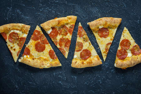 Pepperoni pizza on rustic, vintage style. Top view on dark stone table.の写真素材