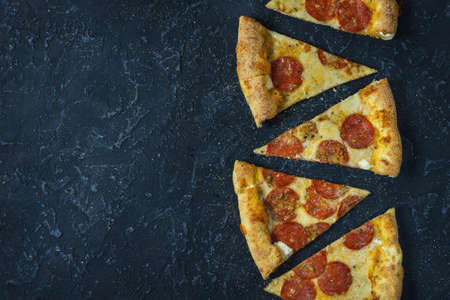 Pepperoni pizza on rustic, vintage style. Top view with copy space on dark stone table.の写真素材