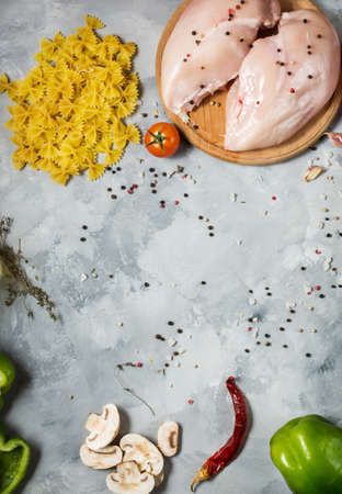 Pasta ingredients. Chicken breasts, Cherry tomatoes, spaghetti pasta and mushrooms on the stone table. Top viewの写真素材