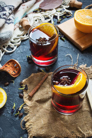 The concept of homemade mulled wine. Mulled wine in a glass on a dark stone backgroundの写真素材