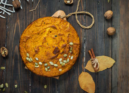Homemade Pumpkin Pie with Autumn Decoration on rustic wood background. Top view