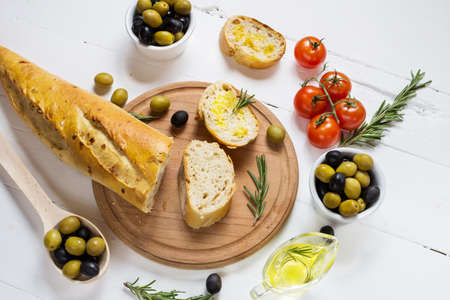 Black and green olives in wooden bowls on wood white background. Top viewの写真素材