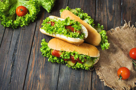 Hot dog with pickles and lettuce on wood background.の写真素材