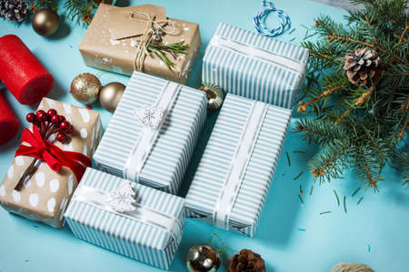 Christmas background with decorations and gift boxes on blue board.