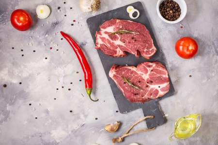 Raw meat steak with seasonings on concrete background. Space for text. Steak ready for cooking....