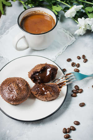 Chocolate cupcakes with a cup of hot black coffee on cocrete background.の写真素材