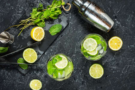 Mojito cocktail with lime and mint in highball glass on a stone table. Drink making tools and ingredients for cocktail. Top viewの写真素材