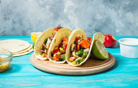 Mexican pork tacos with vegetables. Tacos al pastor on wooden blue rustic backgroundの写真素材