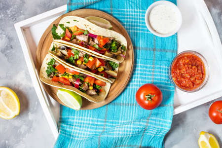 Mexican pork tacos with vegetables. Tacos al pastor on wooden blue rustic background.の写真素材
