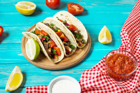 Mexican pork tacos with vegetables. Tacos al pastor on wooden blue rustic background.の写真素材